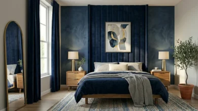 Gray and navy blue bedroom ideas showing a navy velvet headboard, layered bedding, brass accents, and light gray walls