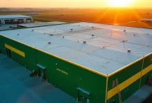 Dubuque roofing company Brent team working on John Deere facility commercial roof installation with safety equipment