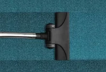 Technician using machine for professional carpet cleaning in a modern living room