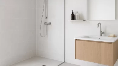 Modern bathroom with linear stainless steel shower drain and wall-mounted stainless steel shower shelf.
