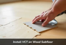 Professional installer laying VCT tiles on prepared wood subfloor with underlayment and adhesive in residential room