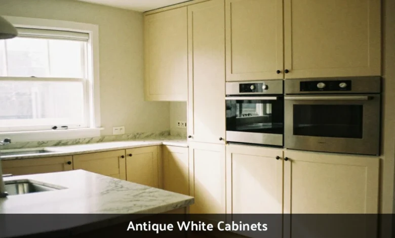 Modern kitchen with antique white shaker cabinets featuring warm cream tones and classic hardware