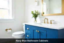 Navy blue bathroom cabinets with white countertop and brass hardware in modern bathroom