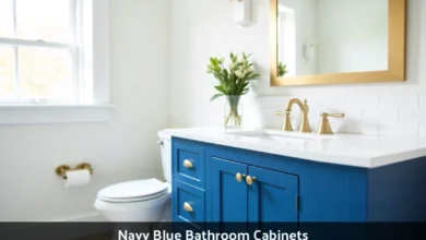 Navy blue bathroom cabinets with white countertop and brass hardware in modern bathroom
