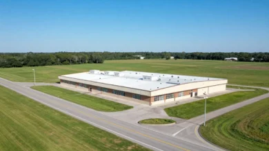 Aerial view of commercial property with land for sale along a highway in a semi-rural area
