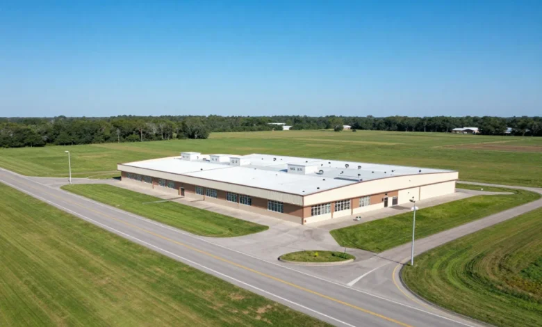Aerial view of commercial property with land for sale along a highway in a semi-rural area