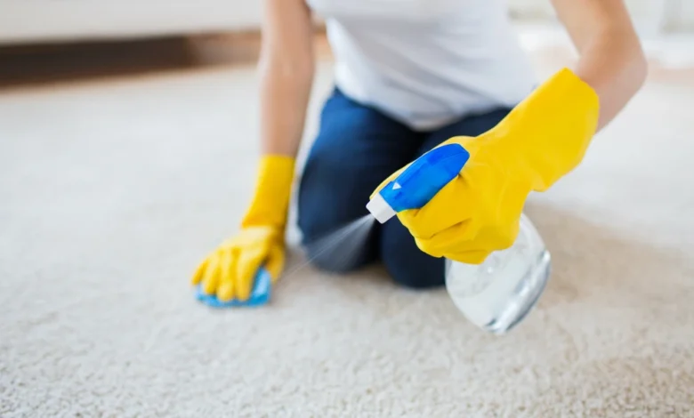 Person blotting grease and oil stains on carpet using a cloth and baking soda