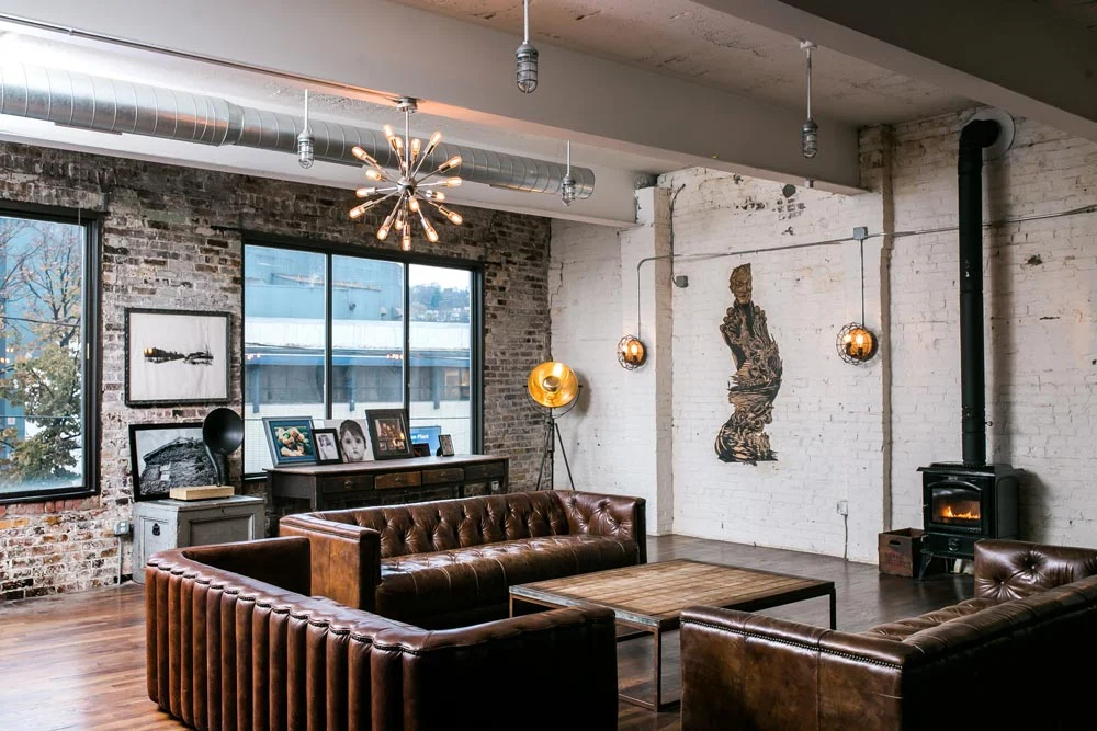 John Fetterman's loft living room with exposed brick leather sofas and visible ductwork